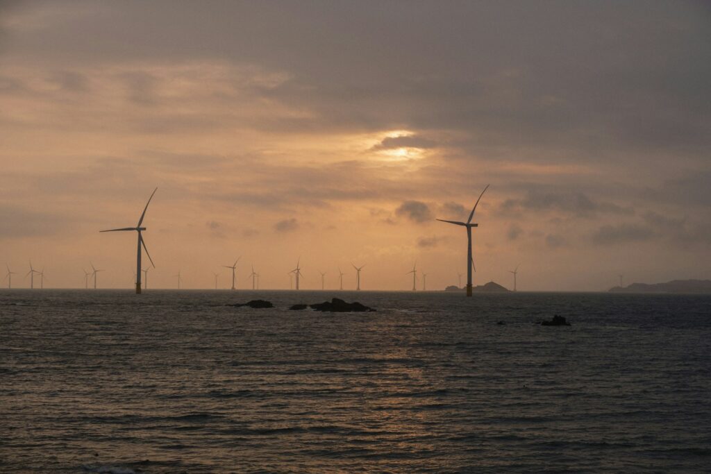 Wind turbines in the ocean at sunset